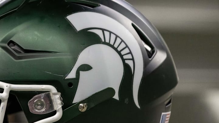 Nov 24, 2023; Detroit, Michigan, USA; A Michigan State Spartans helmet sits on a bench during the second half game against the Penn State Nittany Lions at Ford Field. Mandatory Credit: David Reginek-Imagn Images Nov 24, 2023; Detroit, Michigan, USA; A Michigan State Spartans helmet sits on a bench during the second half game against the Penn State Nittany Lions at Ford Field. Mandatory Credit: David Reginek-Imagn Images