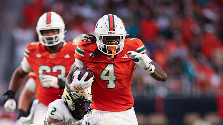 Sep 13, 2025; Miami Gardens, Florida, USA; Miami Hurricanes running back Mark Fletcher Jr. (4) breaks a tackle from South Florida Bulls safety Tavin Ward (2) to score touchdown in the second quarter  at Hard Rock Stadium. Mandatory Credit: Nathan Ray Seebeck-Imagn Images