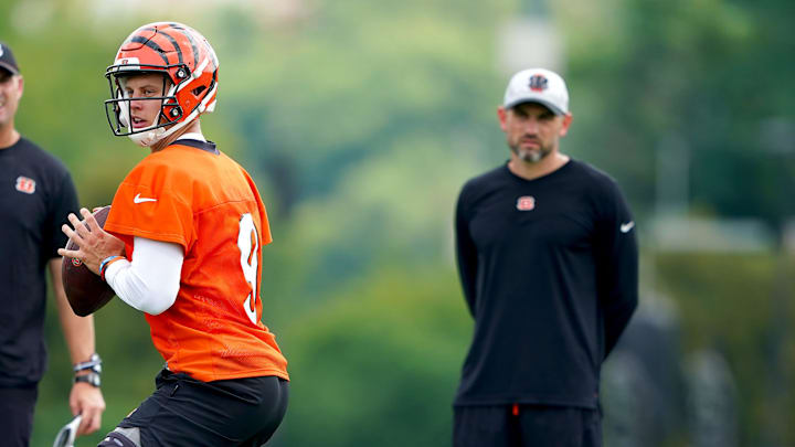 Cincinnati Bengals quarterback Joe Burrow (9) drops back to throw as Cincinnati Bengals head coach Zac Taylor, left, and quarterbacks coach Dan Pitcher observe, Monday, Aug. 16, 2021, at the practice fields next to Paul Brown Stadium in Cincinnati.
