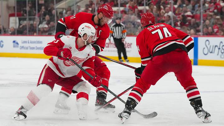 Feb 28, 2026; Raleigh, North Carolina, USA; Carolina Hurricanes center Jordan Staal (11) and defenseman Jaccob Slavin (74) take the puck away from Detroit Red Wings center Dylan Larkin (71) during the second period at Lenovo Center. Mandatory Credit: James Guillory-Imagn Images