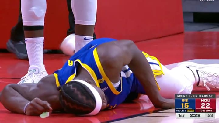 Golden State Warriors star Jimmy Butler lays on the ground after falling to the ground from a collision.