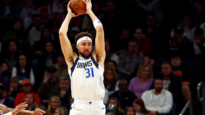 Dec 27, 2024; Phoenix, Arizona, USA; Dallas Mavericks guard Klay Thompson (31) handles the ball against Phoenix Suns guard Monte Morris (23) during the second quarter at Footprint Center. Mandatory Credit: Mark J. Rebilas-Imagn Images