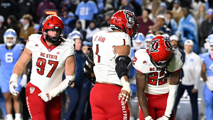 Nov 30, 2024; Chapel Hill, North Carolina, USA; North Carolina State Wolfpack cornerback Jackson Vick (22) celebrates with defensive end Davin Vann (1) after sacking North Carolina Tar Heels quarterback Jacolby Criswell (12) leaving 7 seconds in the fourth quarter at Kenan Memorial Stadium. Mandatory Credit: Bob Donnan-Imagn Images