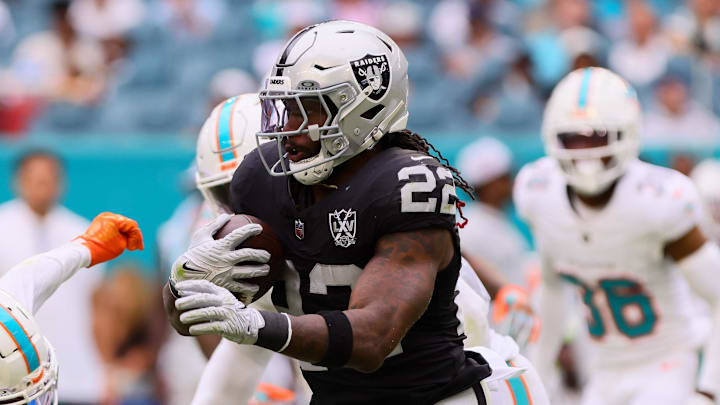 Nov 17, 2024; Miami Gardens, Florida, USA; Las Vegas Raiders running back Alexander Mattison (22) runs with the football against Miami Dolphins cornerback Kader Kohou (4) during the fourth quarter at Hard Rock Stadium. Mandatory Credit: Sam Navarro-Imagn Images