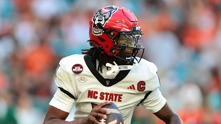 Nov 15, 2025; Miami Gardens, Florida, USA; NC State Wolfpack quarterback CJ Bailey (11) looks for a passing option against the Miami Hurricanes during the second quarter at Hard Rock Stadium. Mandatory Credit: Sam Navarro-Imagn Images