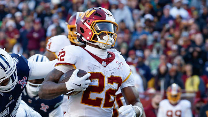 Dec 25, 2025; Landover, Maryland, USA; Washington Commanders running back Jacory Croskey-Merritt (22) avoids a tackle by Dallas Cowboys safety Malik Hooker (28) to score a touchdown in the second quarter at Northwest Stadium. Mandatory Credit: Amber Searls-Imagn Images