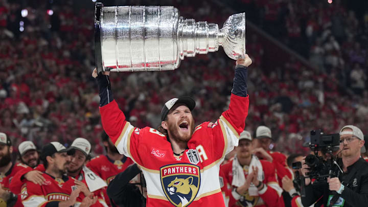 Jun 17, 2025; Sunrise, Florida, USA; Florida Panthers left wing Matthew Tkachuk (19) hoist the Stanley Cup after game six of the 2025 Stanley Cup Final against the Edmonton Oilers at Amerant Bank Arena. Mandatory Credit: Jim Rassol-Imagn Images