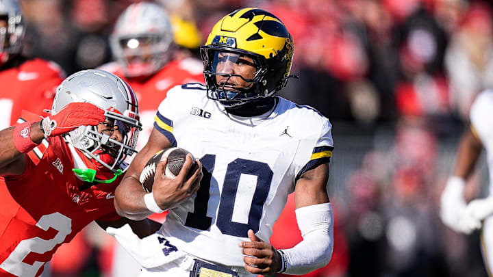 Michigan quarterback Alex Orji (10) runs against Ohio State safety Caleb Downs (2) during the first half at Ohio Stadium in Columbus, Ohio on Saturday, Nov. 30, 2024.