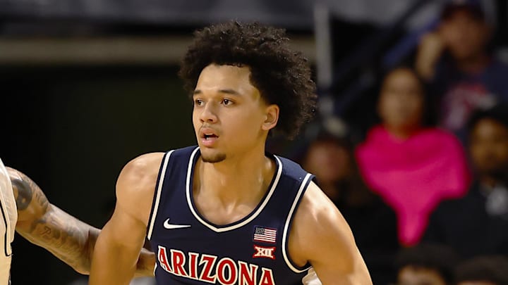 Jan 17, 2026; Orlando, Florida, USA;  Arizona Wildcats guard Brayden Burries (5) dribbles around Central Florida Knights forward Jordan Burks (99) in the first half at Addition Financial Arena. Mandatory Credit: Russell Lansford-Imagn Images