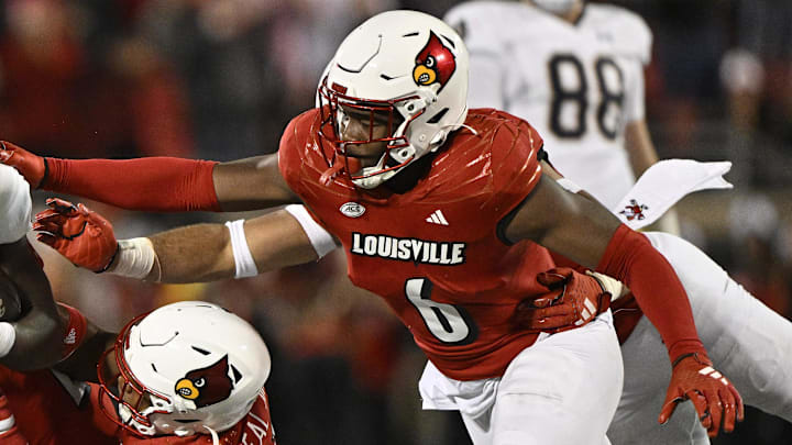 Oct 7, 2023; Louisville, Kentucky, USA; Louisville Cardinals defensive back Devin Neal (27) and Louisville Cardinals linebacker Stanquan Clark (6) tackle Notre Dame Fighting Irish running back Jeremiyah Love (12) during the second half at L&N Federal Credit Union Stadium. Louisville defeated Notre Dame 33-20. Mandatory Credit: Jamie Rhodes-Imagn Images