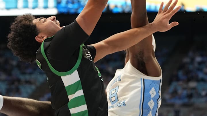 Dec 13, 2025; Chapel Hill, North Carolina, USA; USC Upstate Spartans guard Mason Bendinger (9) has his shot blocked by North Carolina Tar Heels forward Caleb Wilson (8) in the first half at Dean E. Smith Center. Mandatory Credit: Bob Donnan-Imagn Images