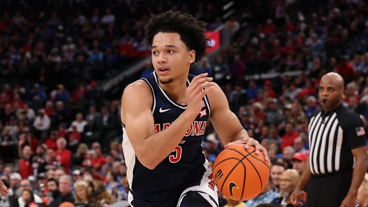 Nov 14, 2025; Inglewood, California, USA;  Arizona Wildcats guard Brayden Burries (5) drives to the basket against UCLA Bruins center Xavier Booker (1) during the first half of the Hall of Fame Series game at Intuit Dome. Mandatory Credit: Kiyoshi Mio-Imagn Images