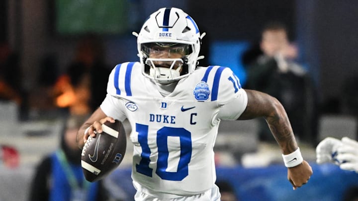 Dec 6, 2025; Charlotte, NC, USA; Duke Blue Devils quarterback Darian Mensah (10) runs with the ball in the second quarter against the Virginia Cavaliers during the 2025 ACC Championship game at Bank of America Stadium. Mandatory Credit: Bob Donnan-Imagn Images Dec 6, 2025; Charlotte, NC, USA; Duke Blue Devils quarterback Darian Mensah (10) runs with the ball in the second quarter against the Virginia Cavaliers during the 2025 ACC Championship game at Bank of America Stadium. Mandatory Credit: Bob Donnan-Imagn Images