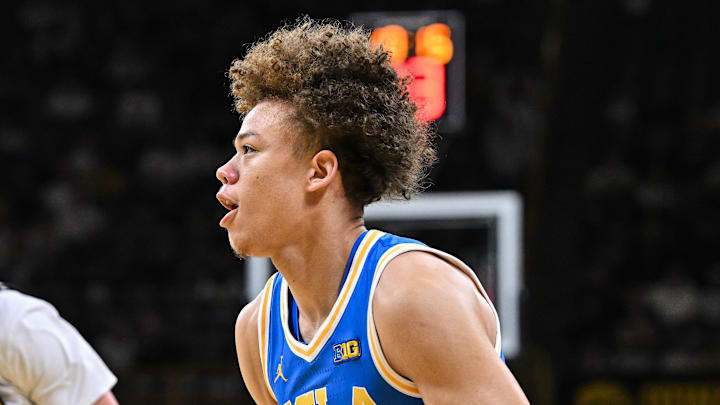 Jan 3, 2026; Iowa City, Iowa, USA; UCLA Bruins guard Trent Perry (0) controls the ball against Iowa Hawkeyes guard Isaia Howard (23) during the first half at Carver-Hawkeye Arena. Mandatory Credit: Jeffrey Becker-Imagn Images