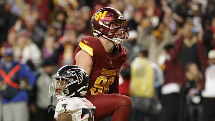Dec 29, 2024; Landover, Maryland, USA; Washington Commanders tight end Zach Ertz (86) celebrates after scoring the game winning touchdown in front of Atlanta Falcons cornerback Dee Alford (20) during overtime at Northwest Stadium. Mandatory Credit: Amber Searls-Imagn Images