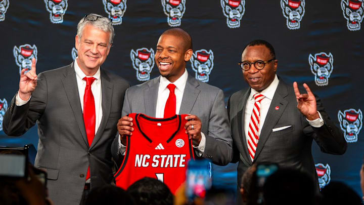 NC State AD Boo Corrigan, men's basketball coach Justin Gainey and Chancellor Kevin Howell pose at Gainey's introductory press conference at the Lenovo Center on Wednesday, April 1, 2026. NC State AD Boo Corrigan, men's basketball coach Justin Gainey and Chancellor Kevin Howell pose at Gainey's introductory press conference at the Lenovo Center on Wednesday, April 1, 2026.