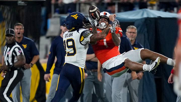 Sep 19, 2026; Charlotte, North Carolina, USA; Virginia Cavaliers receiver Rico Flores (1) is upended by West Virginia Mountaineers cornerback Nick Taylor (19) during the second half at Bank of America Stadium. Mandatory Credit: Jim Dedmon-Imagn Images Sep 19, 2026; Charlotte, North Carolina, USA; Virginia Cavaliers receiver Rico Flores (1) is upended by West Virginia Mountaineers cornerback Nick Taylor (19) during the second half at Bank of America Stadium. Mandatory Credit: Jim Dedmon-Imagn Images