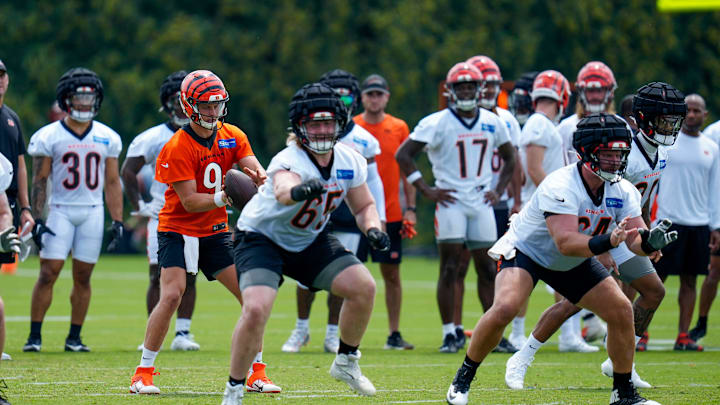 Cincinnati Bengals quarterback Joe Burrow (9) takes a snap behind the offensive line during a training camp practice at the Paycor Stadium practice field in downtown Cincinnati on Wednesday, July 26, 2023.