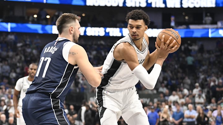 Oct 24, 2024; Dallas, Texas, USA; San Antonio Spurs center Victor Wembanyama (1) looks to move the ball past Dallas Mavericks guard Luka Doncic (77) during the first quarter at the American Airlines Center. Mandatory Credit: Jerome Miron-Imagn Images