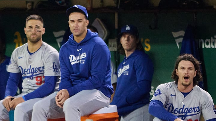 Dodgers outfielder Kevin Kiermaier (93) (center), outfielder Andy Pages (44) (left), outfielder James Outman (33) (right) and their teammates watch the game from the dugout against the Oakland Athletics during the eighth inning at Oakland-Alameda County Coliseum on Aug. 2.