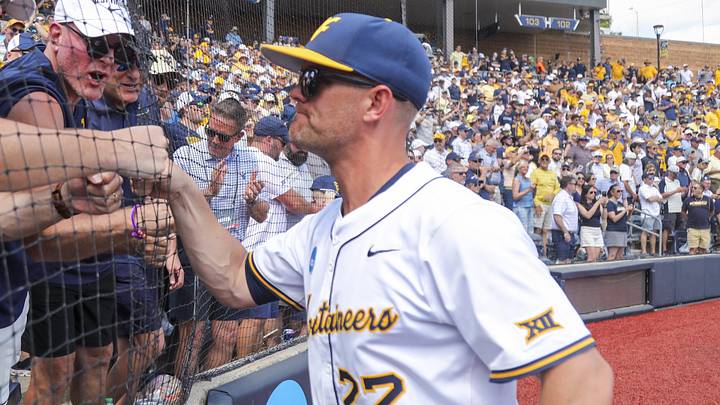 Jun 5, 2026; Morgantown, WV, USA; West Virginia Mountaineers head coach Steve Sabins celebrates with Pat McAfee in the stands after defeating the Cal Poly Mustangs at Kendrick Family Ballpark. Mandatory Credit: Ben Queen-Imagn Images
