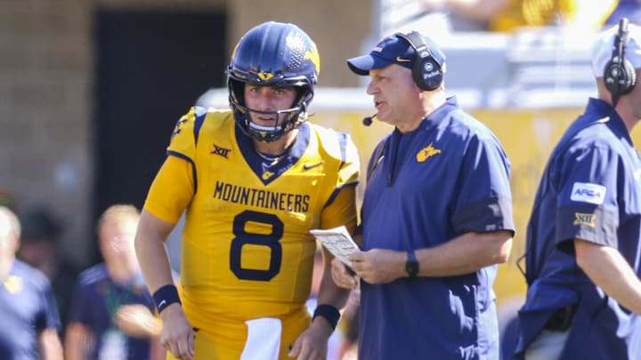 Aug 30, 2025; Morgantown, West Virginia, USA; West Virginia Mountaineers head coach Rich Rodriguez talks to West Virginia Mountaineers quarterback Nicco Marchiol (8) during the second quarter against the Robert Morris Colonials at Milan Puskar Stadium. Mandatory Credit: Ben Queen-Imagn Images