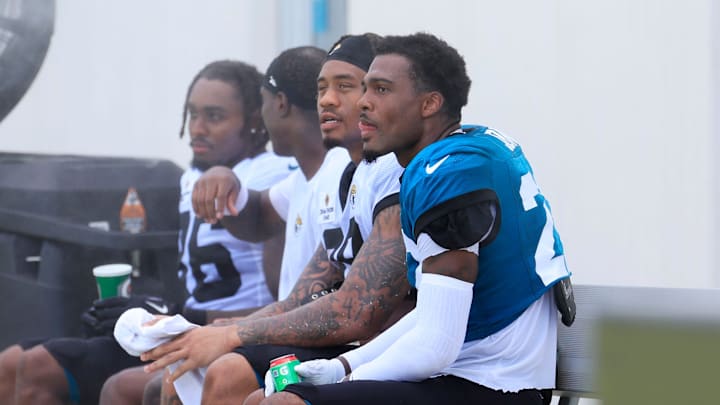Jacksonville Jaguars cornerback Jarrian Jones (22), from right, sits next to running back Ja'Quinden Jackson (38), running back Travis Etienne Jr. (1) and running back LeQuint Allen Jr. (36) as they cool off and talk after an NFL training camp session at the Miller Electric Center, Thursday, Aug. 14, 2025 in Jacksonville, Fla.