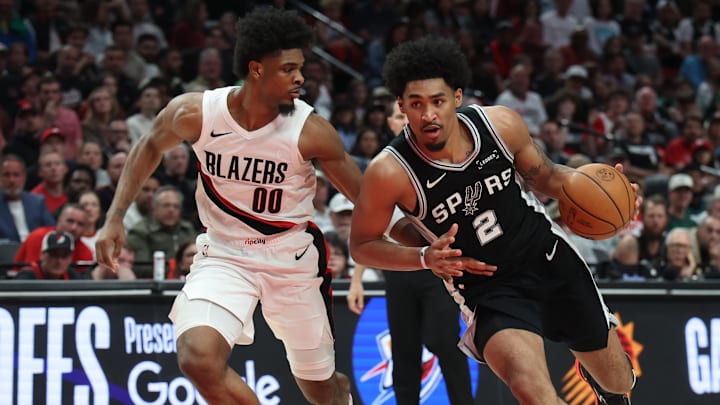 Apr 24, 2026; Portland, Oregon, USA; San Antonio Spurs guard Dylan Harper (2) drives to the basket past Portland Trail Blazers guard Scoot Henderson (00) during the second half during Game 3 of the first round of the 2026 NBA Playoffs at Moda Center.