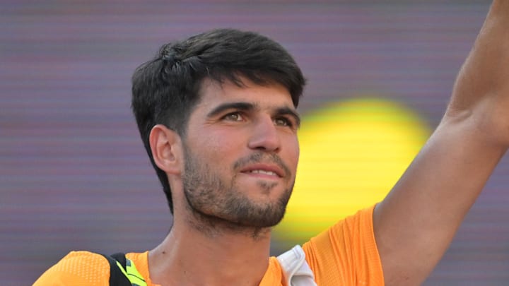 Carlos Alcaraz waves as he leaves the court