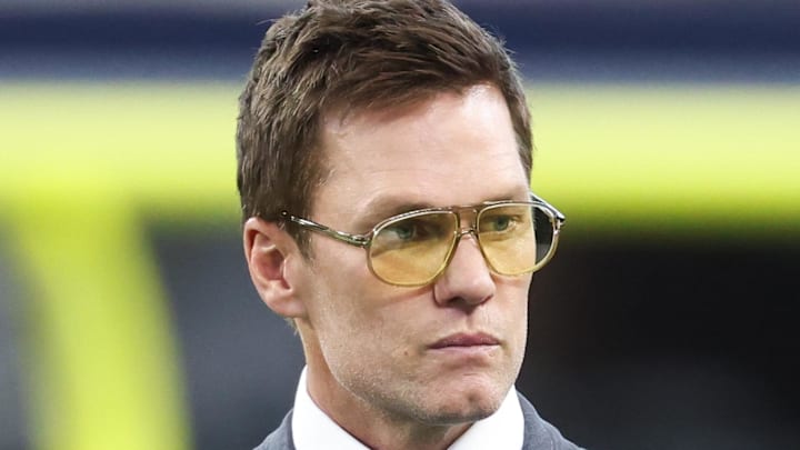 Nov 23, 2025; Arlington, Texas, USA; Former NFL quarterback Tom Brady looks on from the sideline before the game between the Philadelphia Eagles and Dallas Cowboys at AT&T Stadium. Mandatory Credit: Kevin Jairaj-Imagn Images