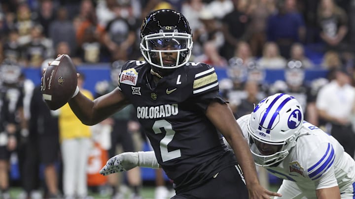 Dec 28, 2024; San Antonio, TX, USA; Colorado Buffaloes quarterback Shedeur Sanders (2) attempts to avoid a tackle by Brigham Young Cougars safety Raider Damuni (3) during the second quarter at Alamodome. Mandatory Credit: Troy Taormina-Imagn Images