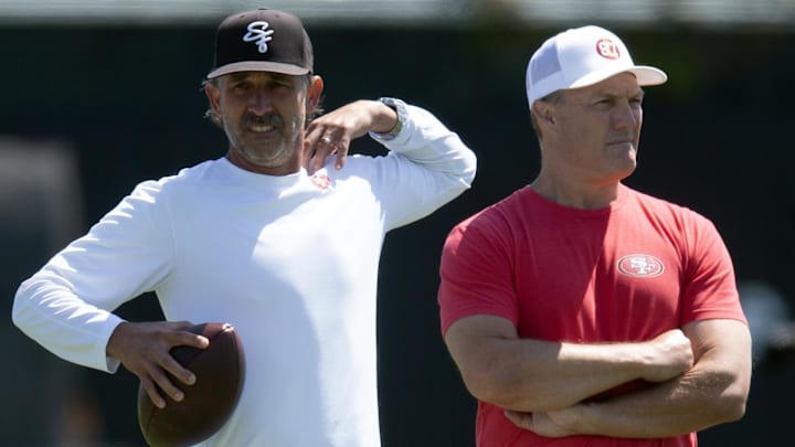 Jun 10, 2025; Santa Clara, CA, USA; San Francisco 49ers head coach Kyle Shanahan (left) and general manager John Lynch watch their team work out during an OTA at Levi's Stadium. Mandatory Credit: D. Ross Cameron-Imagn Images