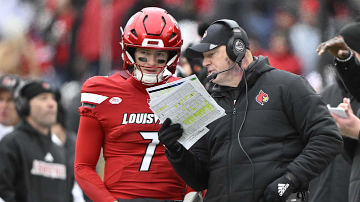 Nov 29, 2025; Louisville, Kentucky, USA; Louisville Cardinals head coach Jeff Brohm talks with Louisville Cardinals quarterback Miller Moss (7) during the second half against the Kentucky Wildcats at L&N Federal Credit Union Stadium. Louisville defeated Kentucky 41-0. Mandatory Credit: Jamie Rhodes-Imagn Images Nov 29, 2025; Louisville, Kentucky, USA; Louisville Cardinals head coach Jeff Brohm talks with Louisville Cardinals quarterback Miller Moss (7) during the second half against the Kentucky Wildcats at L&N Federal Credit Union Stadium. Louisville defeated Kentucky 41-0. Mandatory Credit: Jamie Rhodes-Imagn Images
