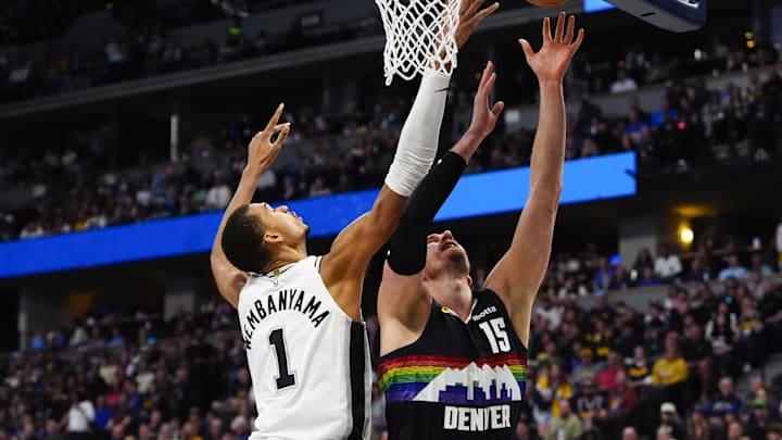 Apr 4, 2026; Denver, Colorado, USA; San Antonio Spurs forward Victor Wembanyama (1) rebounds against Denver Nuggets center Nikola Jokic (15) in the first quarter at Ball Arena. Mandatory Credit: Ron Chenoy-Imagn Images