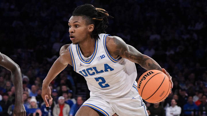 Dec 21, 2024; New York, NY, USA; UCLA Bruins guard Dylan Andrews (2) drives to the basket while being defended by North Carolina Tar Heels guard Drake Powell (9) during the first half at Madison Square Garden. Mandatory Credit: John Jones-Imagn Images