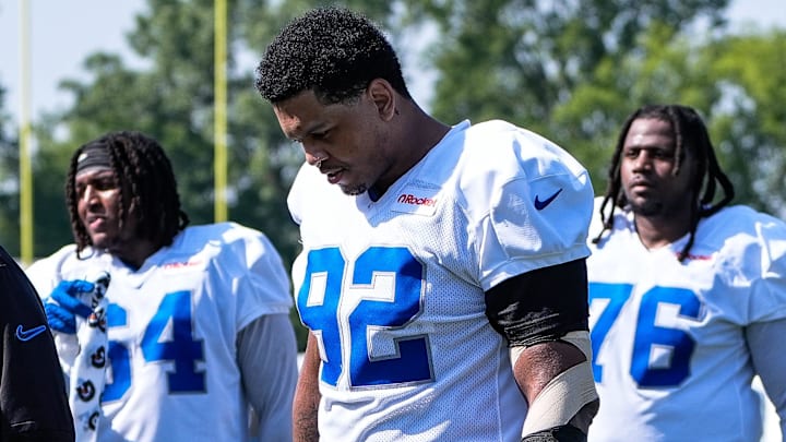 Detroit Lions defensive end Marcus Davenport (92), center, walk off the field after practice during training camp 
