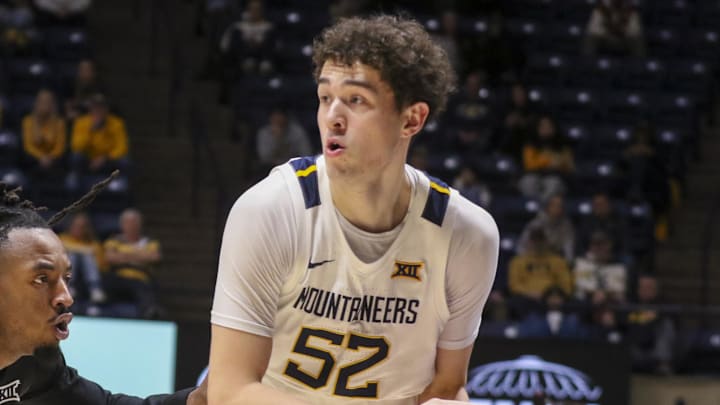 Jan 6, 2026; Morgantown, West Virginia, USA; West Virginia Mountaineers guard Treysen Eaglestaff (52) looks to pass while defended by Cincinnati Bearcats guard Day Day Thomas (1) during the second half at Hope Coliseum. Mandatory Credit: Ben Queen-Imagn Images