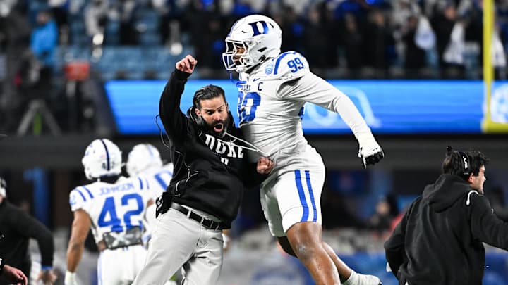 Dec 6, 2025; Charlotte, NC, USA; Duke Blue Devils head coach Manny Diaz reacts with defensive tackle Aaron Hall (99) in the first quarter against the Virginia Cavaliers during the 2025 ACC Championship game at Bank of America Stadium. Mandatory Credit: Bob Donnan-Imagn Images