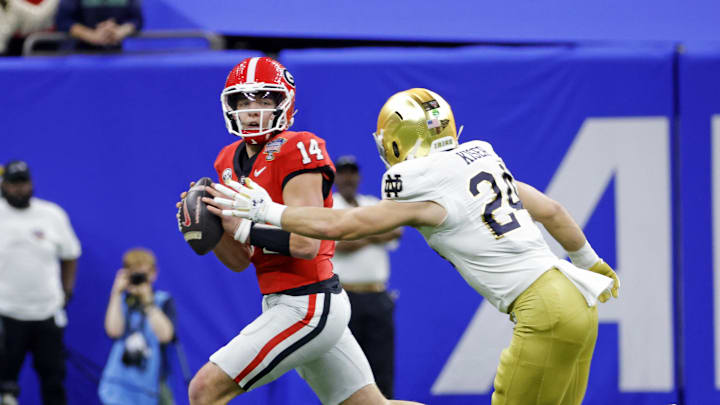 Jan 2, 2025; New Orleans, LA, USA; Georgia Bulldogs quarterback Gunner Stockton (14) controls the ball during the first quarter against Notre Dame Fighting Irish linebacker Jack Kiser (24) at Caesars Superdome. Mandatory Credit: Amber Searls-Imagn Images