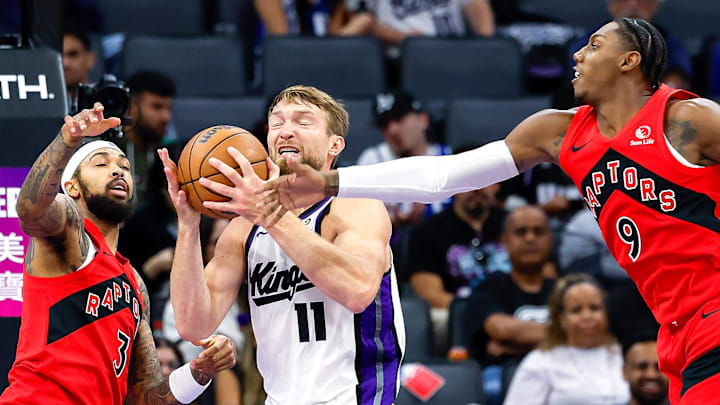 Sacramento Kings center Domantas Sabonis fights for a rebound against Toronto Raptors forwards Brandon Ingram and RJ Barrett