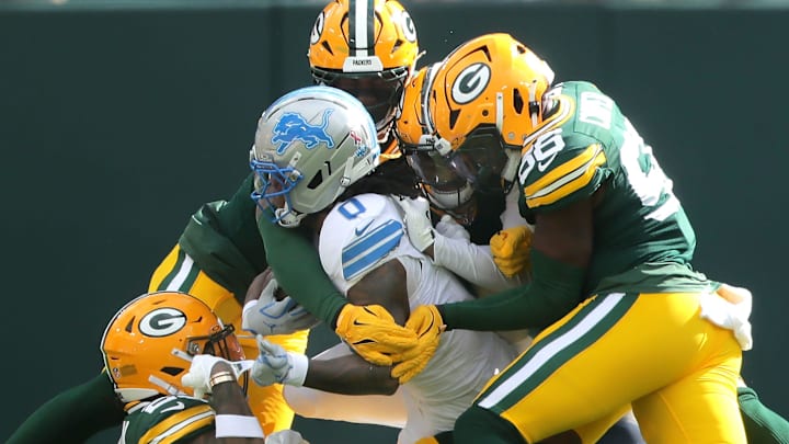 Green Bay Packers defenders, including Keisean Nixon (bottom), tackle Detroit Lions running back Jahmyr Gibbs.