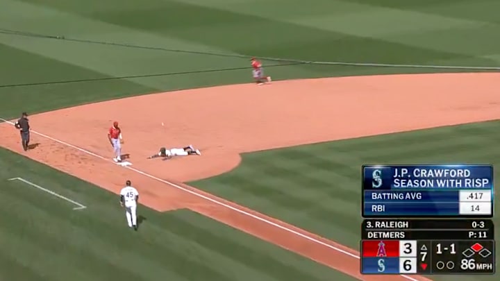 Seattle Mariners OF Julio Rodriguez dives under a ball while running the bases.