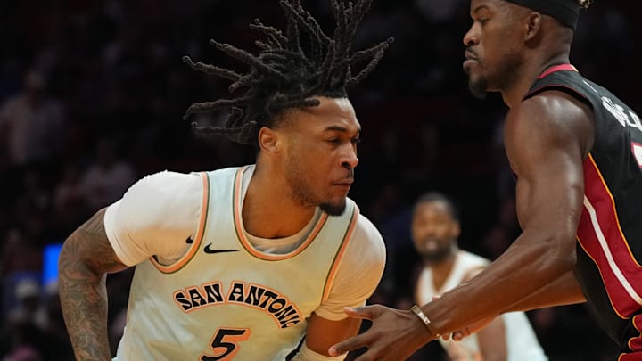 Jan 19, 2025; Miami, Florida, USA;  San Antonio Spurs guard Stephon Castle (5) drives toward the basket as Miami Heat forward Jimmy Butler (22) defends during the first half at Kaseya Center. Mandatory Credit: Jim Rassol-Imagn Images