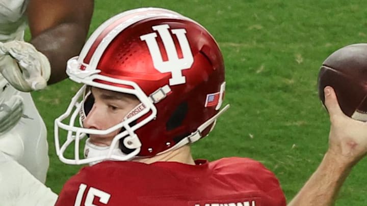 Jan 19, 2026; Miami Gardens, FL, USA; Indiana Hoosiers quarterback Fernando Mendoza (15) passes the ball under pressure by Miami Hurricanes defensive lineman Rueben Bain Jr. (4) in the third quarter during the College Football Playoff National Championship game at Hard Rock Stadium. Mandatory Credit: Kim Klement Neitzel-Imagn Images