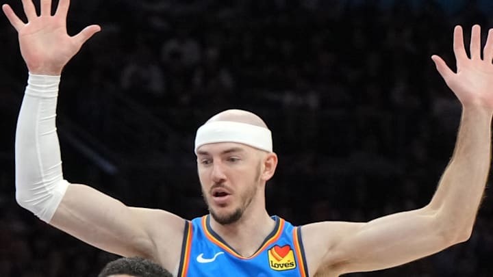 Apr 25, 2026; Phoenix, Arizona, USA; Phoenix Suns guard Devin Booker (1) drives between Oklahoma City Thunder guard Alex Caruso (9) and guard Shai Gilgeous-Alexander (2) in the second half during game three of the first round of the 2026 NBA Playoffs at Mortgage Matchup Center. Mandatory Credit: Rick Scuteri-Imagn Images
