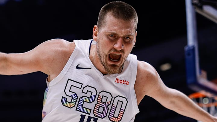 Mar 26, 2025; Denver, Colorado, USA; Denver Nuggets center Nikola Jokic (15) reacts as he goes out of bounds as Milwaukee Bucks guard AJ Green (20) looks on in the first quarter at Ball Arena. Mandatory Credit: Isaiah J. Downing-Imagn Images
