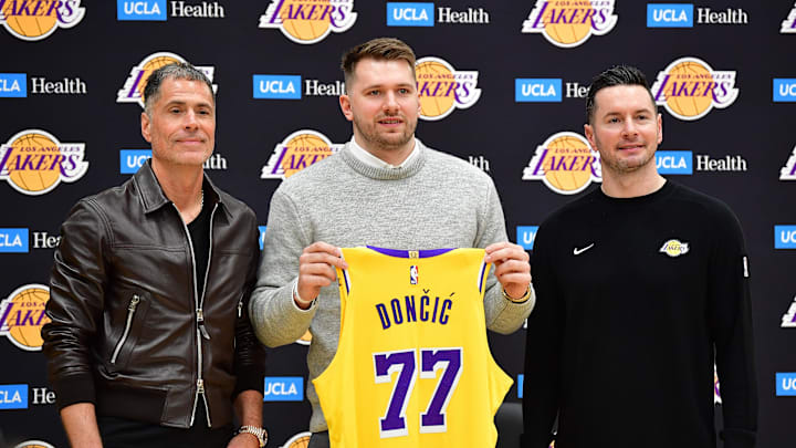 Los Angeles Lakers guard Luka Doncic poses for photos with general manager Rob Pelinka and head coach JJ Redick.