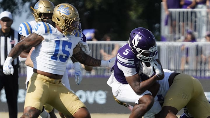 Sep 27, 2025; Evanston, Illinois, USA; Northwestern Wildcats running back Caleb Komolafe (5) runs the ball against the UCLA Bruins during the first half at Northwestern Medicine Field at Martin Stadium. Mandatory Credit: David Banks-Imagn Images