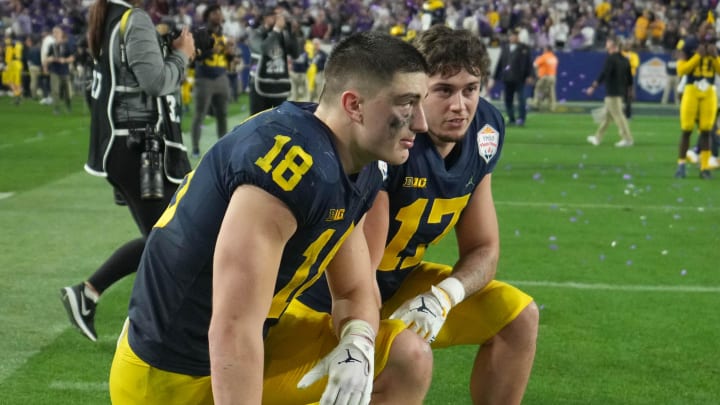 Dec 31, 2022; Glendale, Arizona, USA; Michigan Wolverines tight ends Colston Loveland (18) and Marlin Klein (17) kneel on the field after after losing to the TCU Horned Frogs in the 2022 Fiesta Bowl at State Farm Stadium.