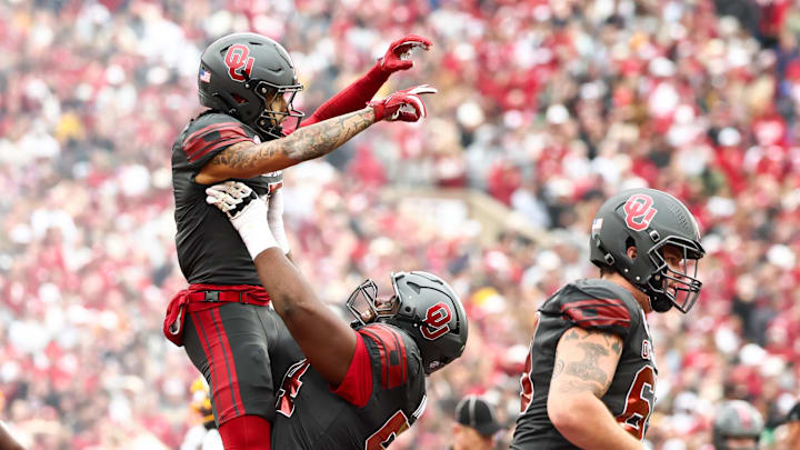 Oklahoma wide receiver Isaiah Sategna III (5) celebrates with  offensive lineman Febechi Nwaiwu.